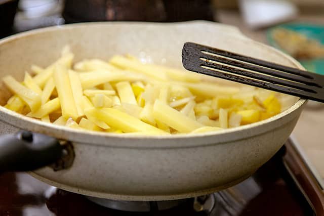 Papas fritas en sartén con aceite caliente