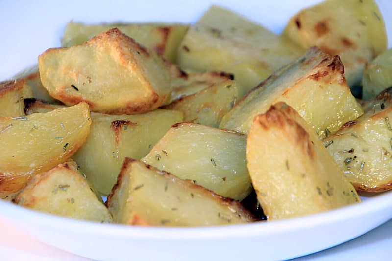 Papas fritas cortadas en cuadrados, doradas y crujientes.