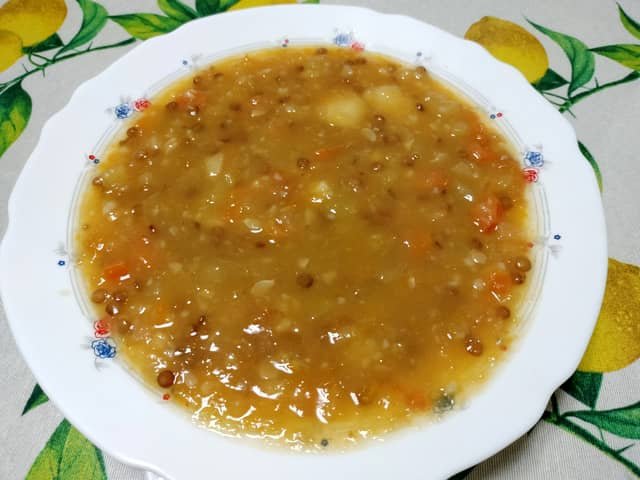 Reposar y servir el potaje de lentejas canario y vegano, listo en el plato.